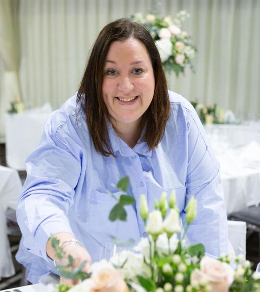 Emma arranging flowers on table