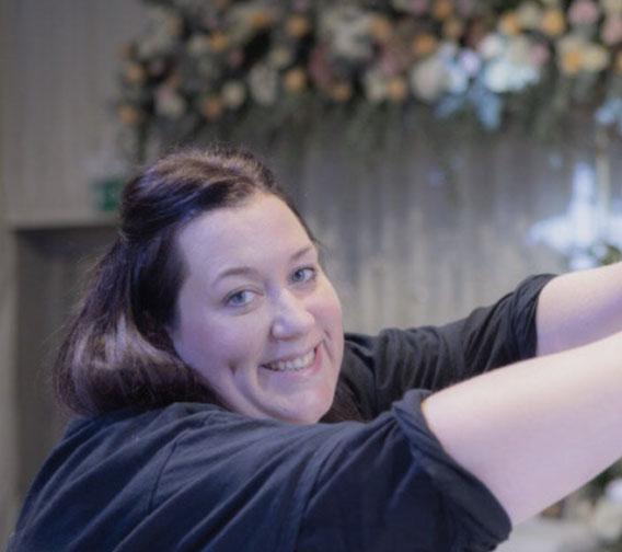 Emma fixing flowers at a wedding